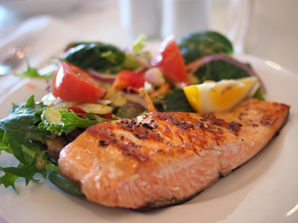 Air-fried salmon fillet with lemon and herbs on a plate
